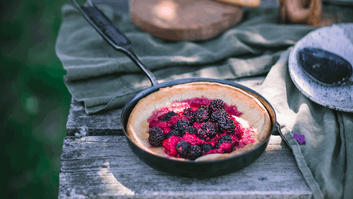 Dutch baby with raspberries baked in an 8" carbon steel saute pan made by Northwest Skillet Company.